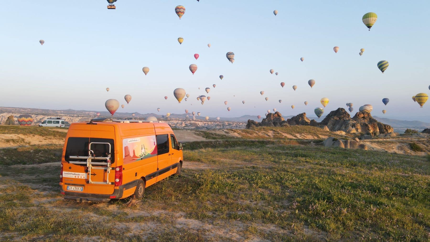camper arancione di fronte alle mongolfiere in cappadocia - Guida alla Cappadocia in Van e Camper